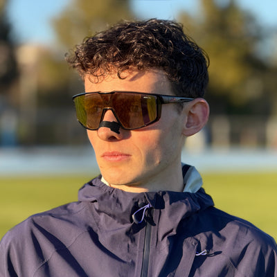 Noé Faivre, athlète Vigur, porte une bande nasale noire et des lunettes de sport sur une piste d'athlétisme